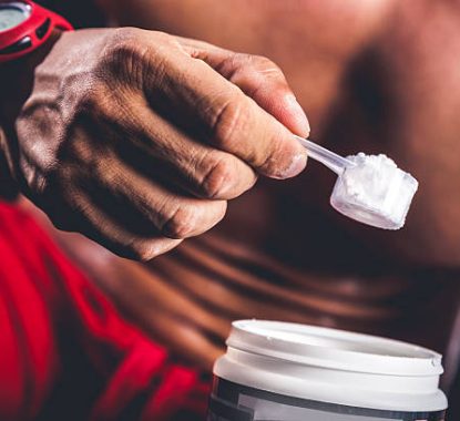 Man holding protein bottle after workout.